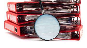 red binders and magnifying glass