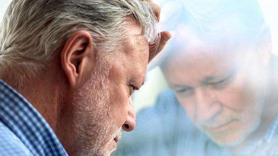 older worker leaning against window